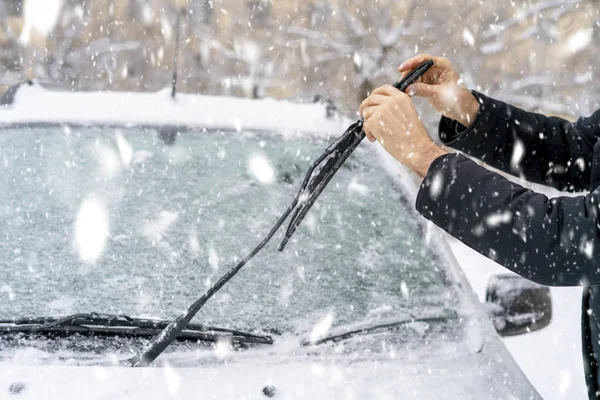 Homem ajustando e limpando limpadores de carro em tempo nevado b — Fotografia de Stock