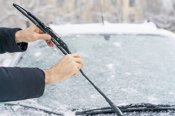 Man adjusting and cleaning wipers of car in snowy weather b — Stock Photo, Image