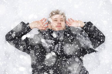 Genç adam kar kar yağışı z yere yalan kaplı