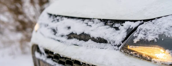 white car front covered in snow in winter season b