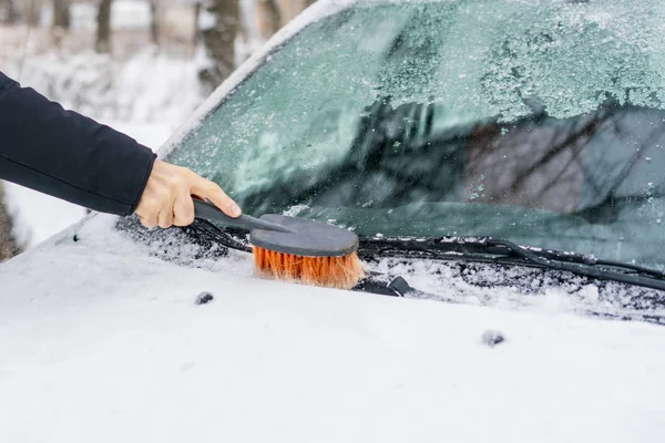 Mão limpando o pára-brisas de neve e gelo em uma estação de inverno — Fotografia de Stock