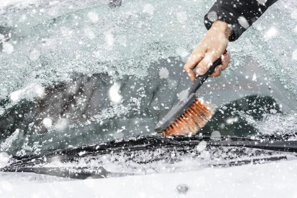 Mão limpando o pára-brisas de neve e gelo em uma estação de inverno — Fotografia de Stock