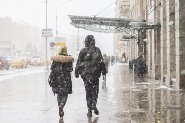 insanlar şehir sokaklarını snowall b altında yürümek