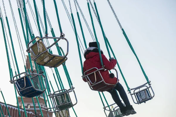 Criança se divertindo montando em um carrossel cadeia no parque de diversões b — Fotografia de Stock