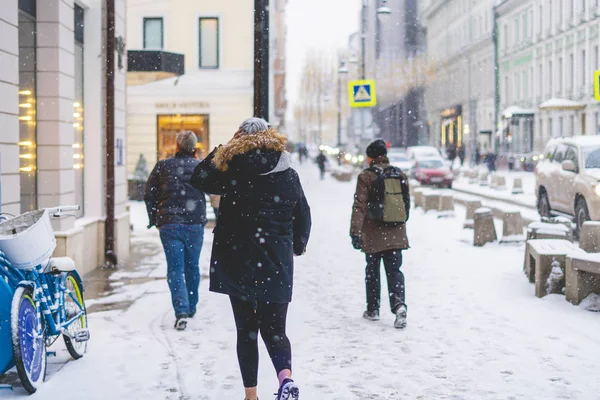 person walk in city streets in winter season under snowfall b