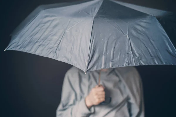 Joven triste hombre mantenga paraguas en mal tiempo sobre fondo oscuro b d — Foto de Stock