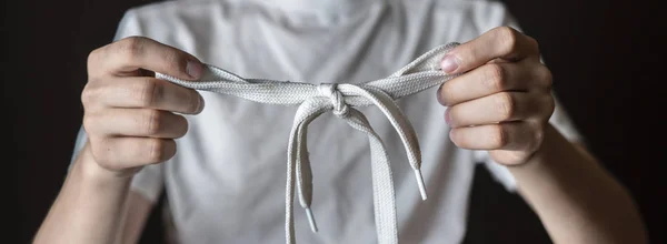 Молодий чоловік тримає зв'язаний шнурок ізольований f — стокове фото