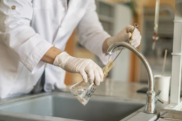 Scientist wash beaker from poisonous acid after experiments b — Stock Photo, Image