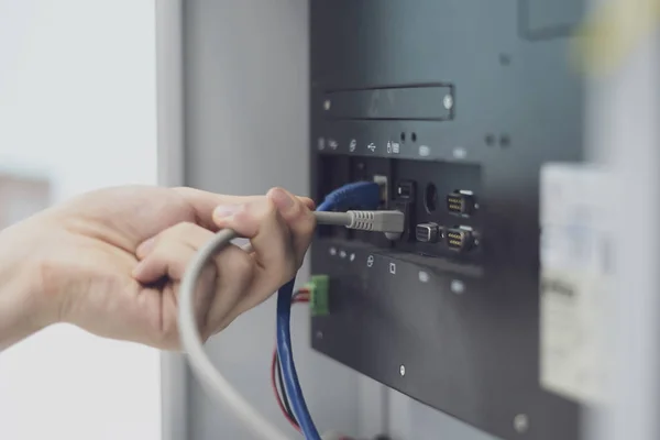 Eletricista ajustar ou instalar a comunicação no painel elétrico — Fotografia de Stock