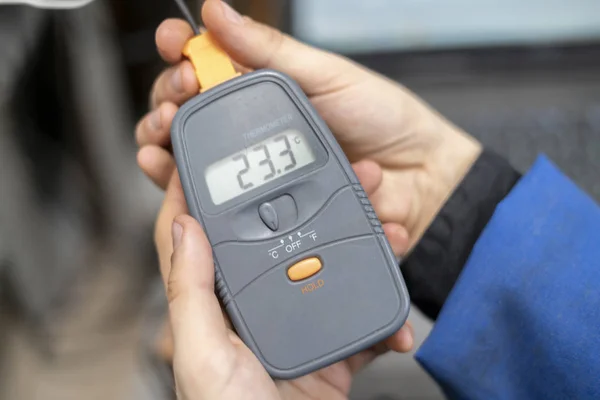 Arbeiter in blauer Uniform halten Stromzähler in der Hand, um die Spannung b zu überprüfen — Stockfoto