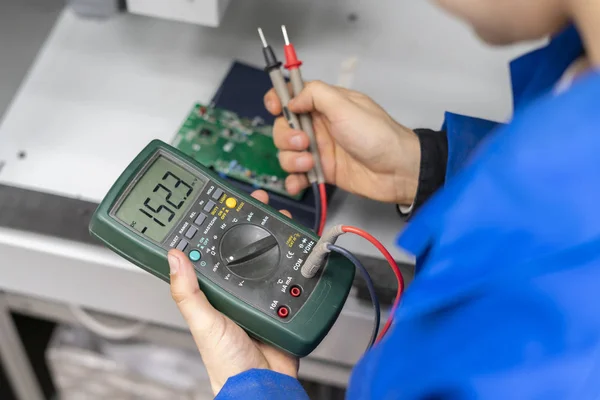 Arbeiter verwenden elektrisches Multimeter und überprüfen Spannung b — Stockfoto