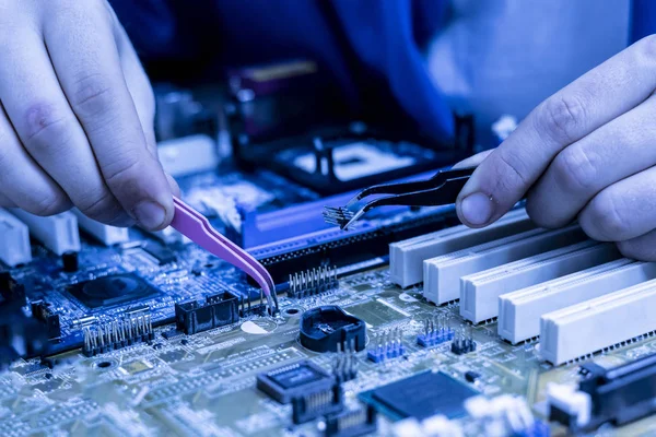 teknisyen bir devre kartına transistör yüklemek b