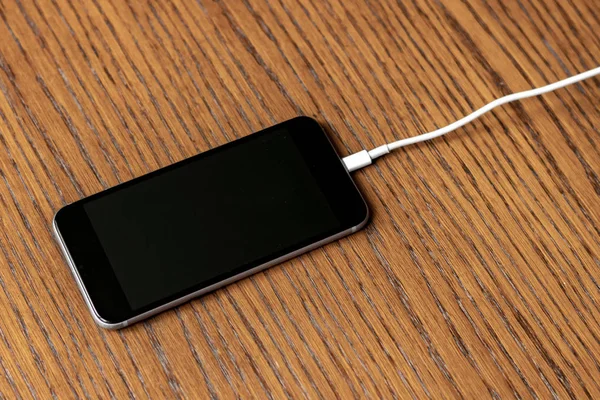 Зарядный провод, вставленный в смартфон изолирован b — стоковое фото