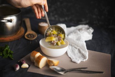 şefler el beyaz boş bir kase, gıda hazırlıkları taze sıcak çorba dökün