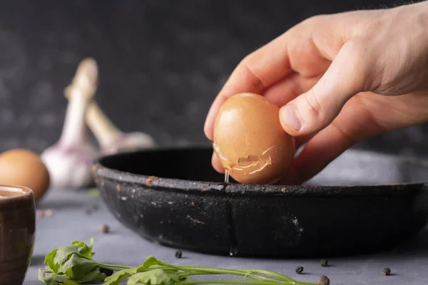 Pessoas mão segurar ovo rachado e despeje uma gema de ovo e proteína em uma frigideira para cozinhá-lo, estilos rústicos — Fotografia de Stock