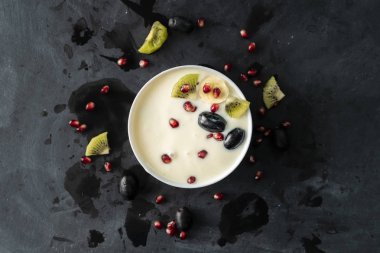 tropikal meyve, kivi, muz, garnet, üzüm küçük parçalar ile bir seramik kase hafif taze yoğurt