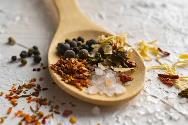 Cerrar cuchara de madera grande con aromática mezcla de pimientos hierbas y especias, culinarios indios — Foto de Stock