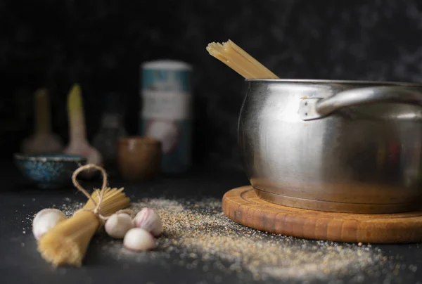 Vue de dessus des spaghettis durs crus dans une casserole en métal, eau bouillante, ingrédients pour la cuisson — Photo