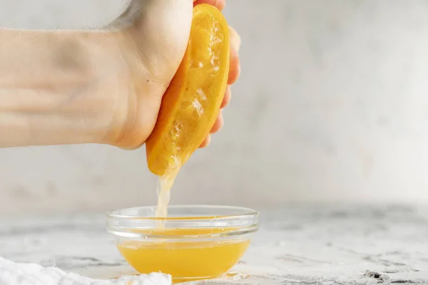 Pessoa aperta o suco de laranja fresco com uma mão nua, bebida sã em uns copos — Fotografia de Stock