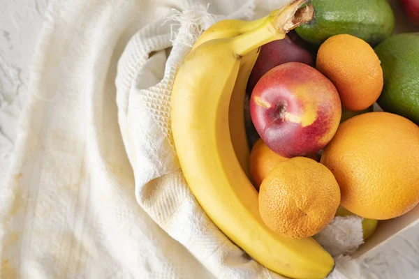 Grande caixa de madeira com frutas frescas maduras, banana, maçã, laranja, tangerina, abacate, alimentos vegetarianos — Fotografia de Stock