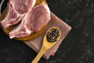 dilimleme tahtası üzerinde ham domuz filetosu, baharat ve biber ile tahta kaşık, yağ abur cubur, pişmemiş