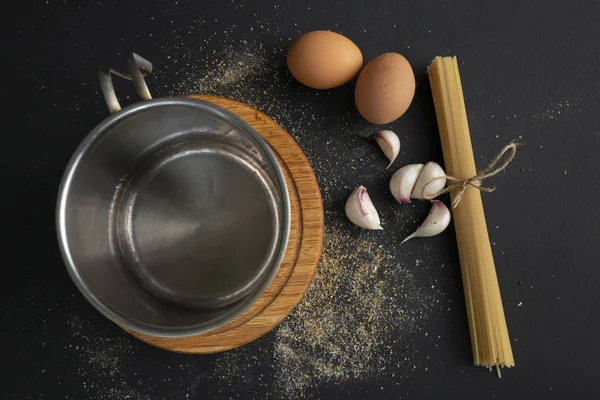 Vue de dessus des spaghettis durs crus dans une casserole en métal, eau bouillante, ingrédients pour la cuisson — Photo