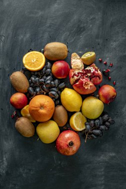 Üzüm, kivi, portakal, egzotik tropikal meyveler gibi grunge bir yüzeyde taze meyve seçimleri düzleştirirdi.