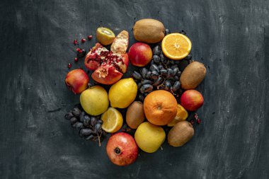 Üzüm, kivi, portakal, egzotik tropikal meyveler gibi grunge bir yüzeyde taze meyve seçimleri düzleştirirdi.