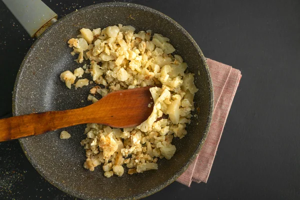 Chou-fleur frit ou rôti dans une poêle sur une planche à découper en bois, petits déjeuners végétariens — Photo