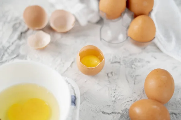 Ovos na mesa com rachaduras em meia, gema e proteína em ovo aberto, ovos mexidos fogões — Fotografia de Stock