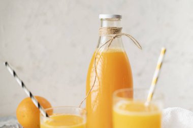 sıkıştırılmış portakal suyu ile cam şişe, yarım portakal etrafında dilimlenmiş