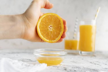 kişi çıplak bir el ile taze portakal suyu sıkmak, bir bardak sağlıklı içecek