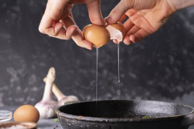 kişiler el kırık yumurta tutun ve pişirmek için bir tavada bir sarısı ve protein dökün, rustik stilleri