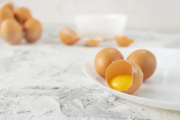 Ovos na mesa com rachaduras em meia, gema e proteína em ovo aberto, ovos mexidos fogões — Fotografia de Stock