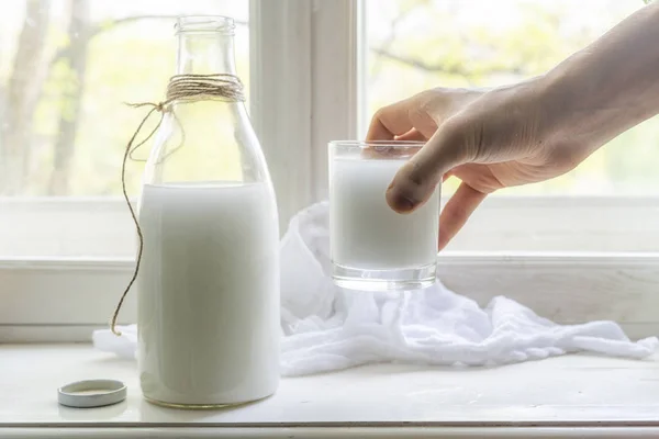 Leite de vaca cru fresco em uma soleira da janela, café da manhã saudável na aldeia, despeje o leite nos vidros — Fotografia de Stock