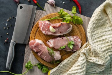 ahşap bir dilimleme veya kesme tahtası üzerinde baharatlı çiğ et, pişmemiş et bir tuz koymak