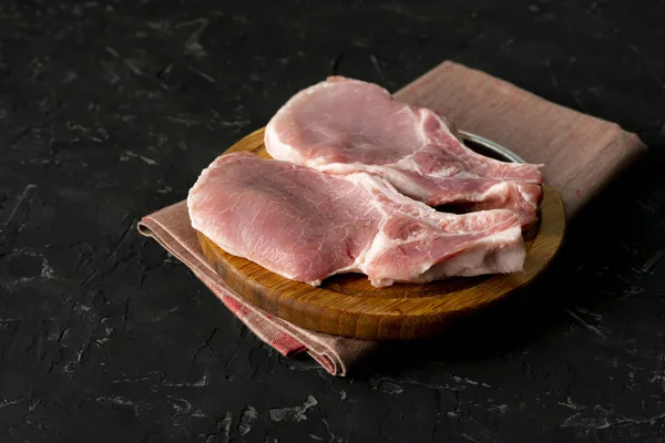 Vista dall'alto di fette crude di carne cruda, carne di maiale tagliata su una tavola di legno isolata — Foto Stock