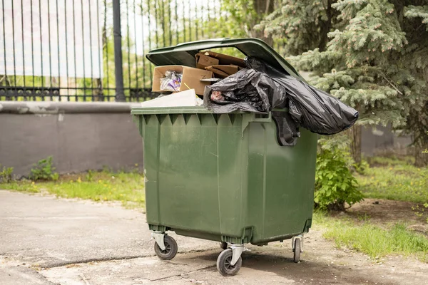 Metal verde viejo lleno de basura contenedor, conceptos de contaminación de la naturaleza — Foto de Stock