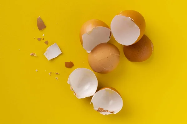 cracked egg shell isolated on yellow background, ingredients for cookings