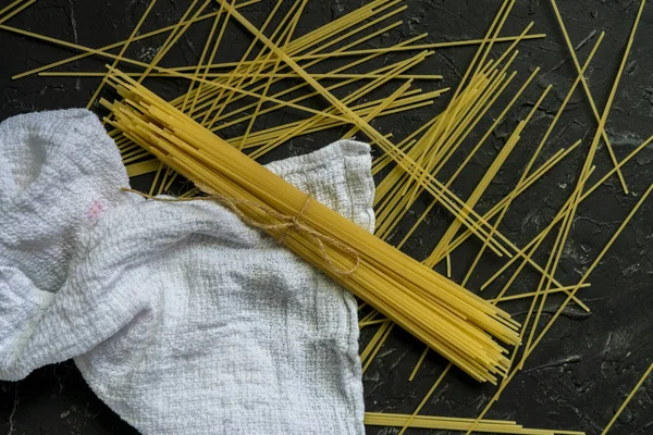 Hromada syrového špagety s plochým výhledem na tmavé povrchy — Stock fotografie