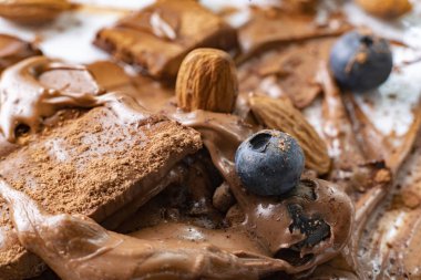 beyaz tabaklarda badem fıstığı ve yaban mersini ile eritilmiş çikolata bar makro çekim