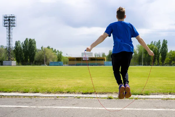 Cvičí sportovec s pokračovací lanem na venkovních stadionech, zvýšení vytrvalosti — Stock fotografie