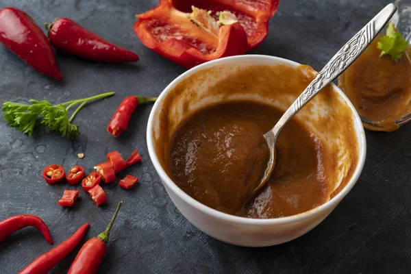 Widok z góry czerwonego pikantny sos z papryki w misce i składniki do gotowania — Zdjęcie stockowe