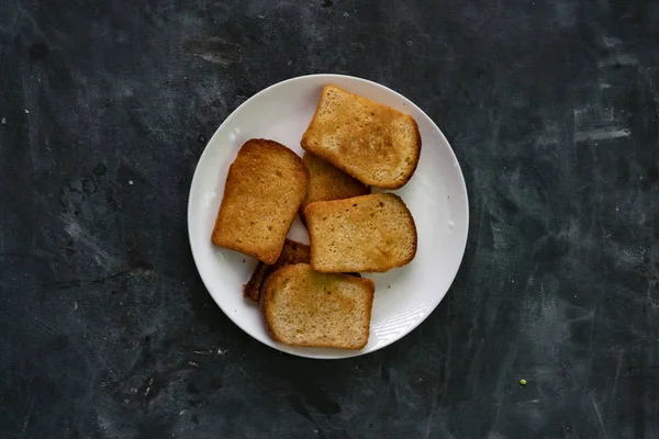 Vers warm geroosterd brood plakjes in de donkere tafel, gezond smakelijk ontbijt — Stockfoto