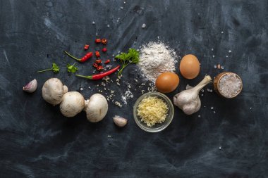 masada yemek pişirmek için ham maddeler, peynir, tuz, biber, yumurta ve koyu bir masada farklı sebzeler