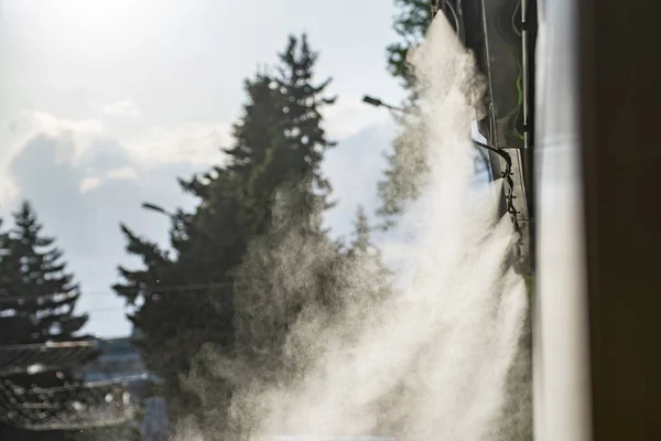 Sistema di spruzzatura ad acqua per il raffreddamento in un caffè pubblico nelle calde giornate estive bollenti — Foto Stock