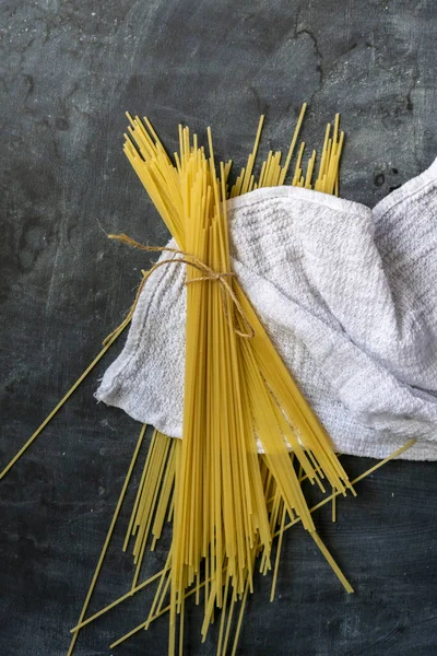 Hromada syrového špagety s plochým výhledem na tmavé povrchy — Stock fotografie