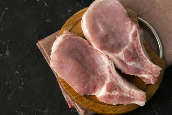 Top view of raw meat uncooked slices, cut pork on a wooden board isolateds Stock Photo