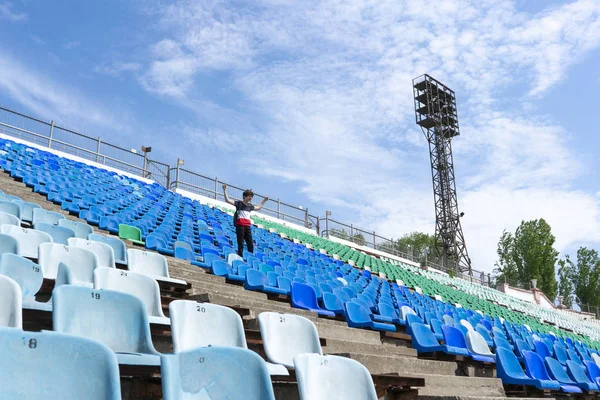 Panorama de enormes asientos del estadio con un hombre viendo los conciertos de eventos musicales —  Fotos de Stock