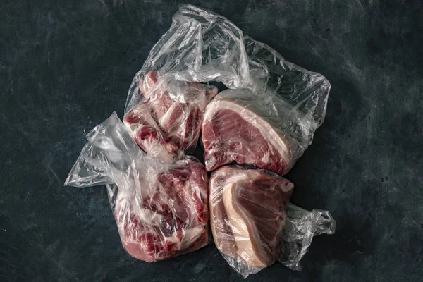 fresh bloody raw meat in a plastic bag straight after purchasing it at the butcherss